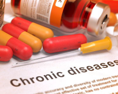 Des capsules de couleur rouge et orange et une fiole de vaccin sont sur le dessus d'un rapport d'Express Scripts Canada portant sur les maladies chroniques.
